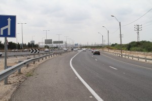 אזור התאונה, התחברות כביש 4 לכביש 4 (מבט מצפון). הרכב עמד בשול הימני, באזור עמוד התאורה האחרון, ומשם עבר לאי התנועה המצויר, במקום בו עומדת מכונית אפורה. 1. בדוח דובר על "השכבה", למרות שקטע הכביש כאן ישר; 2. בגלל שהאופנוע פגע ברכב בניצב, דובר בדוח על התיישרות מההשכבה; 3. בדוח הושמטה לחלוטין העובדה כי הרכב עבר מהשול הימני לאי התנועה המצויר.